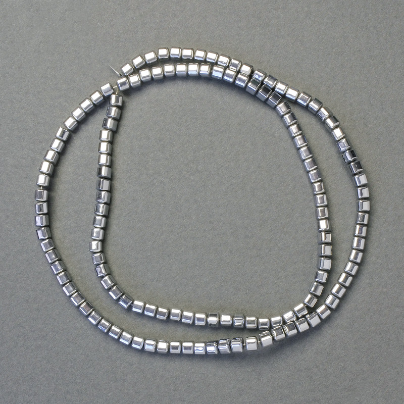 Hämatit-Würfelperlen, silberfarben, Kantenlänge ca. 3×3 mm, auf einer ca. 40 cm langen Schnur aufgefädelt