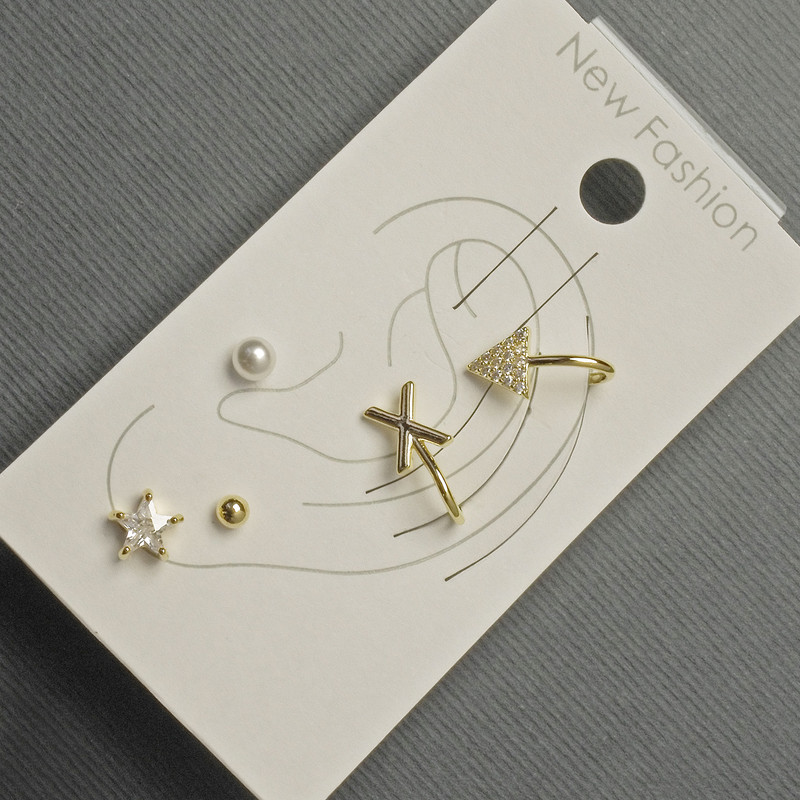 Ohrringe – Stecker und Ohrklemmen am Ohr aus goldfarbenem Metall mit weißen Strasssteinen
