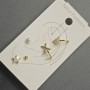 Ohrringe – Stecker und Ohrklemmen am Ohr aus goldfarbenem Metall mit weißen Strasssteinen