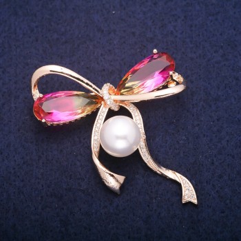 Brosche Schleife mit einer Perle und gelb-rosafarbenen Kristallen im Swarovski-Stil, goldfarbenes Metall 45×47 mm