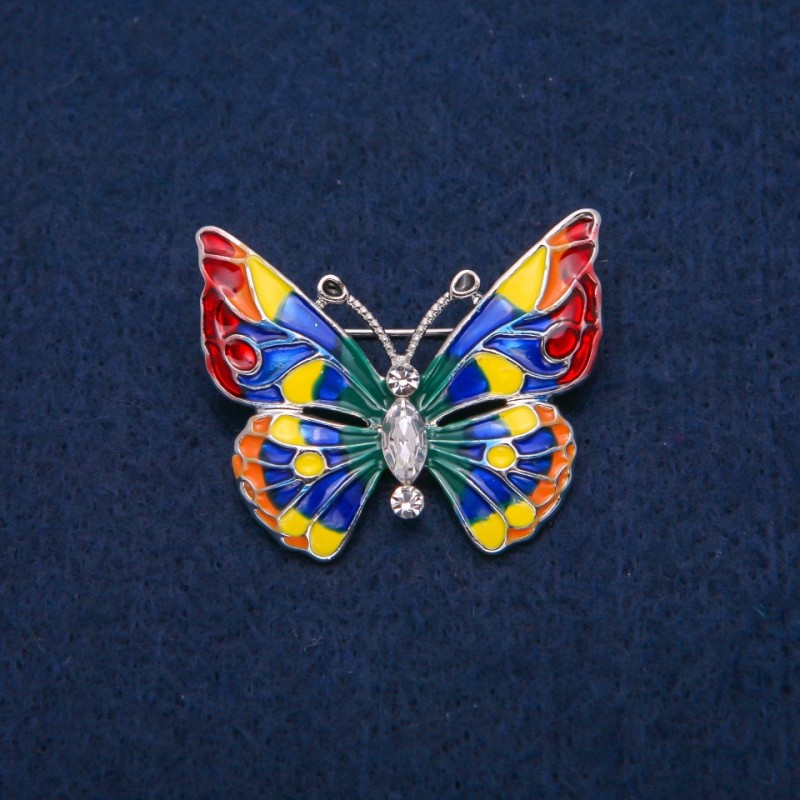 Brosche Schmetterling mit weißen Kristallen und bunter Emaille, goldfarbenes Metall 31 × 37 mm